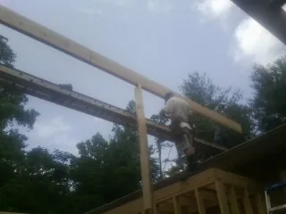 Carpenter setting a ridge beam over a new addition frame — Ice Dam Removal by Roofing Brothers in Ten Mile