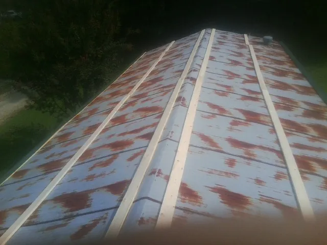 Rusted metal roof panels with new wood purlins before replacement — Storm Damage Roof Repair in Ten Mile by Roofing Brothers