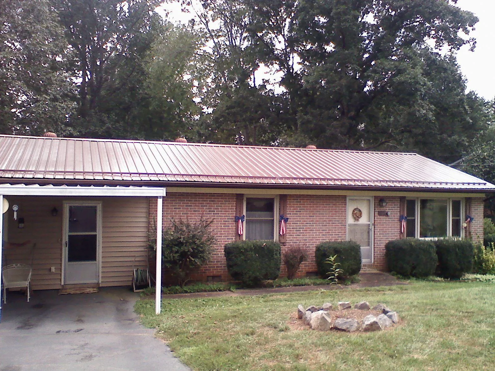 Bronze metal roof and carport on a brick ranch home — Roof Repair work by our crew in Ten Mile